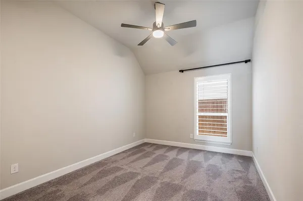 an empty room with a window and a ceiling fan