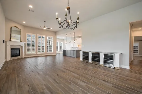 an empty room with wooden floor fireplace and windows