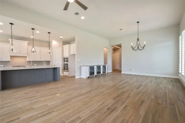 a view of a kitchen with a kitchen island wooden floor and a ceiling fan