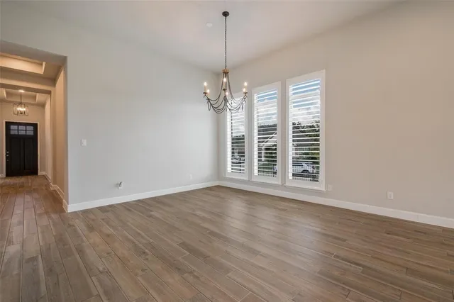 a view of a room with wooden floor chandeliers and a window