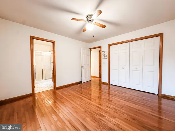an empty room with a window and a ceiling fan