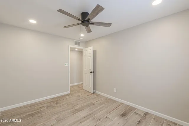an empty room with wooden floor and door