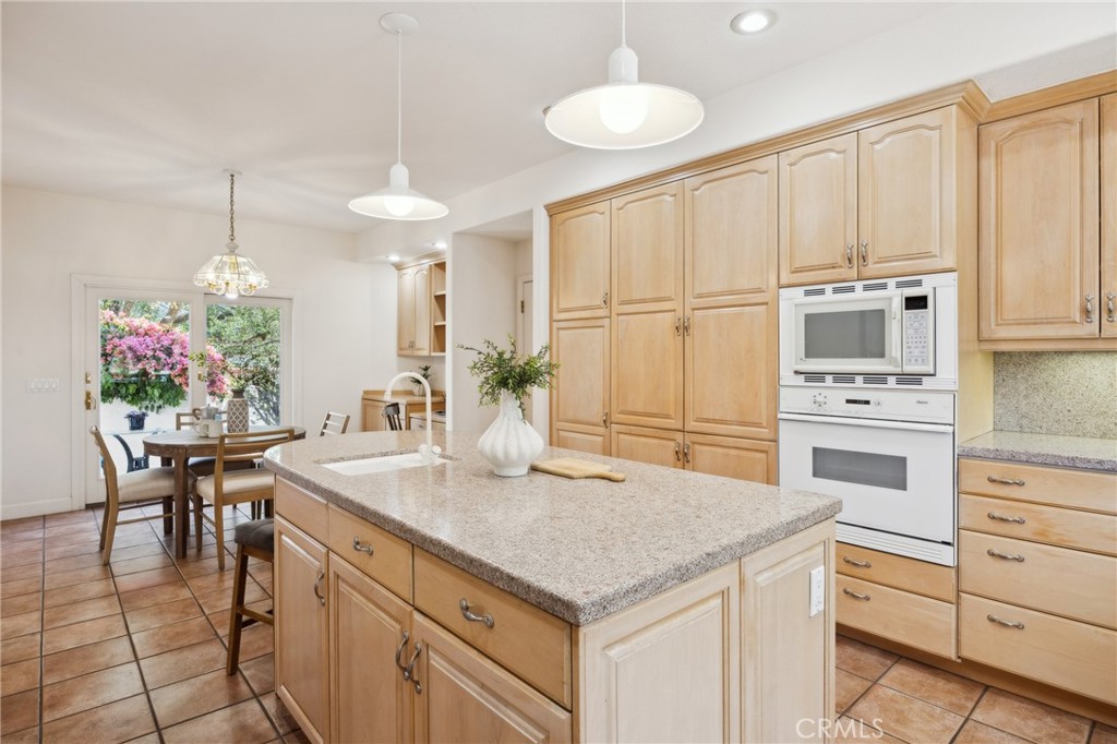 993 Las Palmas Way San Luis Obispo, CA 93401 - Photo 25 of 63 a kitchen with kitchen island granite countertop a table chairs sink and cabinets