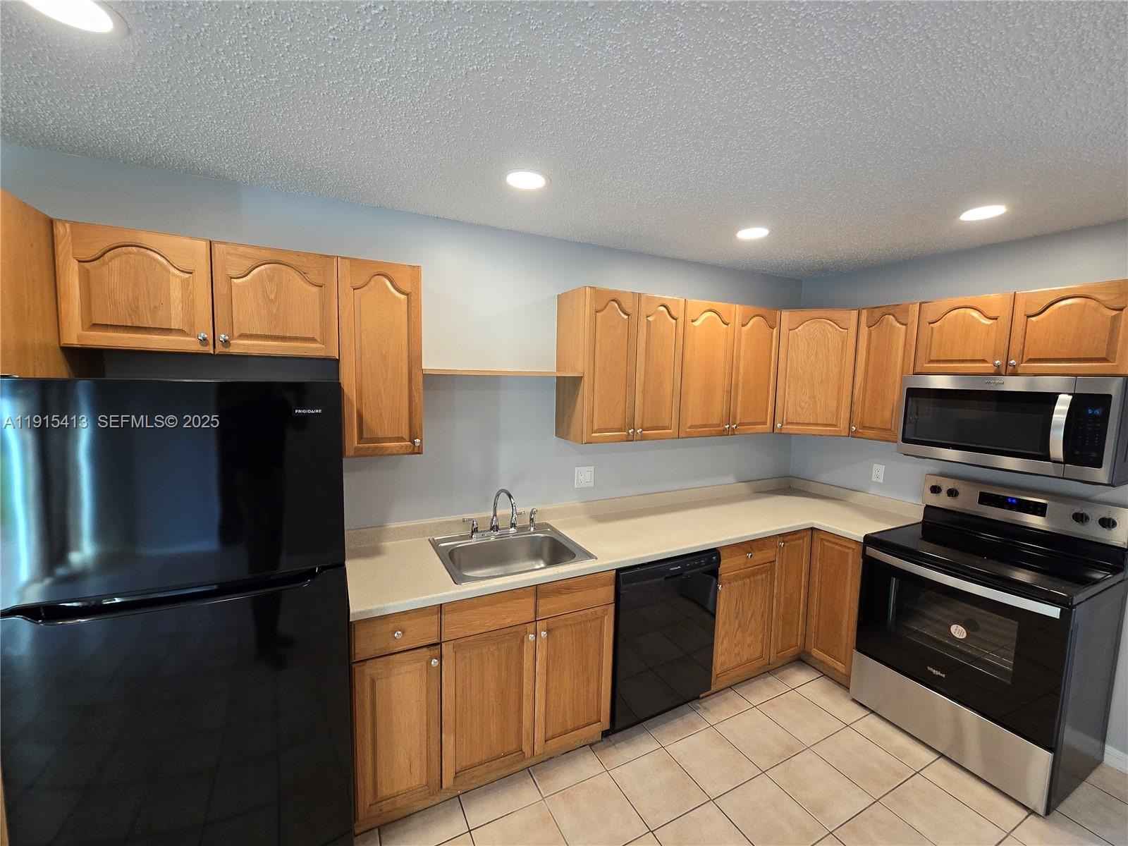 4550 Southeast Salvatori Road Stuart, FL 34997 - Photo 11 of 13 a kitchen with stainless steel appliances granite countertop a refrigerator a sink dishwasher a stove top oven a kitchen island and chairs with wooden floor