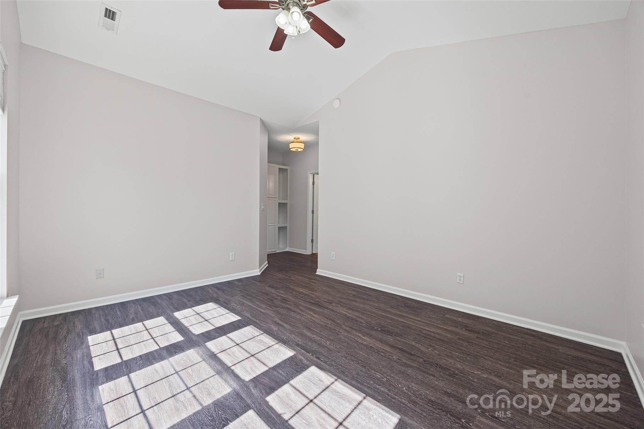 2535 Fossil Stone Lane Fort Mill, SC 29708 - Photo 16 of 43 an empty room with wooden floor fan and windows