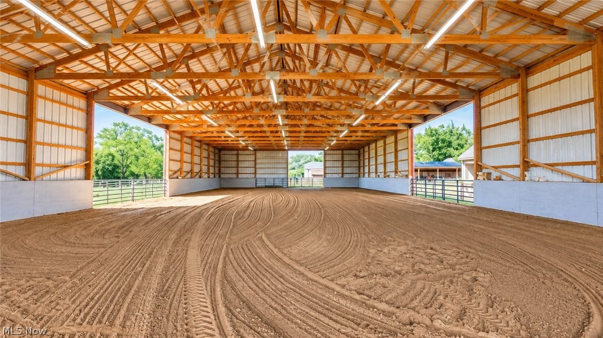 18 Manning Road Mogadore, OH 44260 - Photo 5 of 47 Spacious covered arena with wood beam construction, metal siding, integrated lighting, and a prepared sand footing