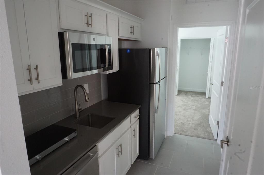 5704 Stephens Road, Unit 1 St. Cloud, FL 34771 - Photo 6 of 8 a kitchen with stainless steel appliances granite countertop a refrigerator and a sink