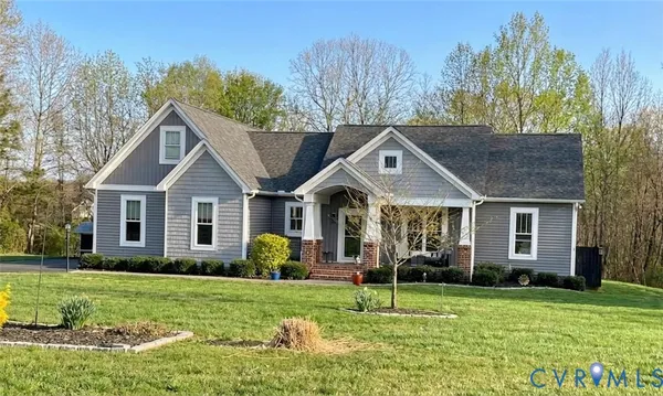 a front view of a house with a yard and trees