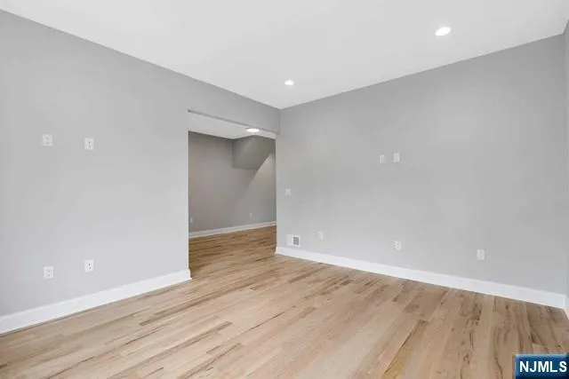a view of an empty room with wooden floor