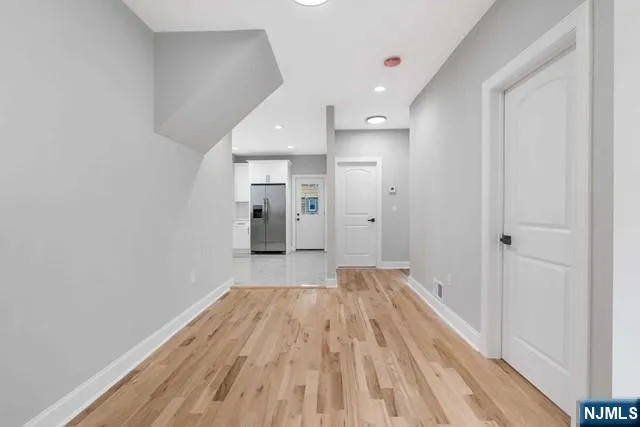 a view of a room with wooden floor and a hallway