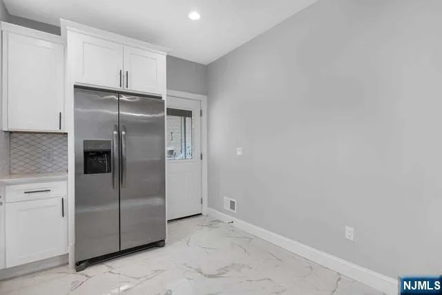 a metallic refrigerator freezer sitting in a kitchen