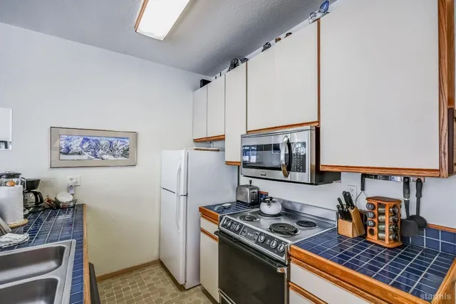 a kitchen with stainless steel appliances granite countertop a stove a refrigerator and a microwave