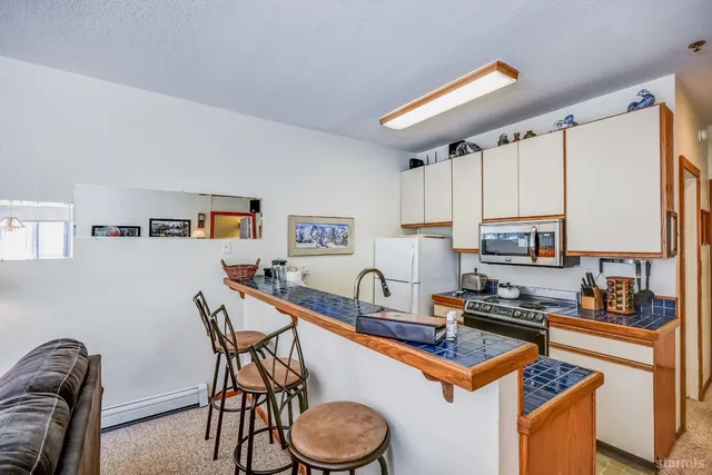 a kitchen with stainless steel appliances granite countertop a stove top oven a sink a counter space and cabinets