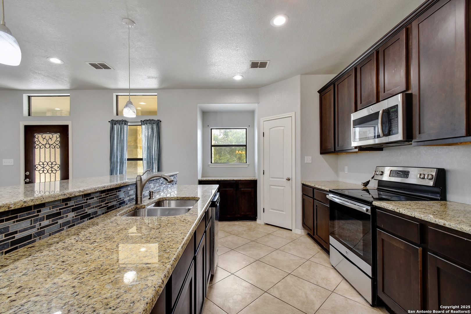 1010 Persimmon Pass Fischer, TX 78623 - Photo 11 of 26 a kitchen with stainless steel appliances granite countertop a sink stove and microwave