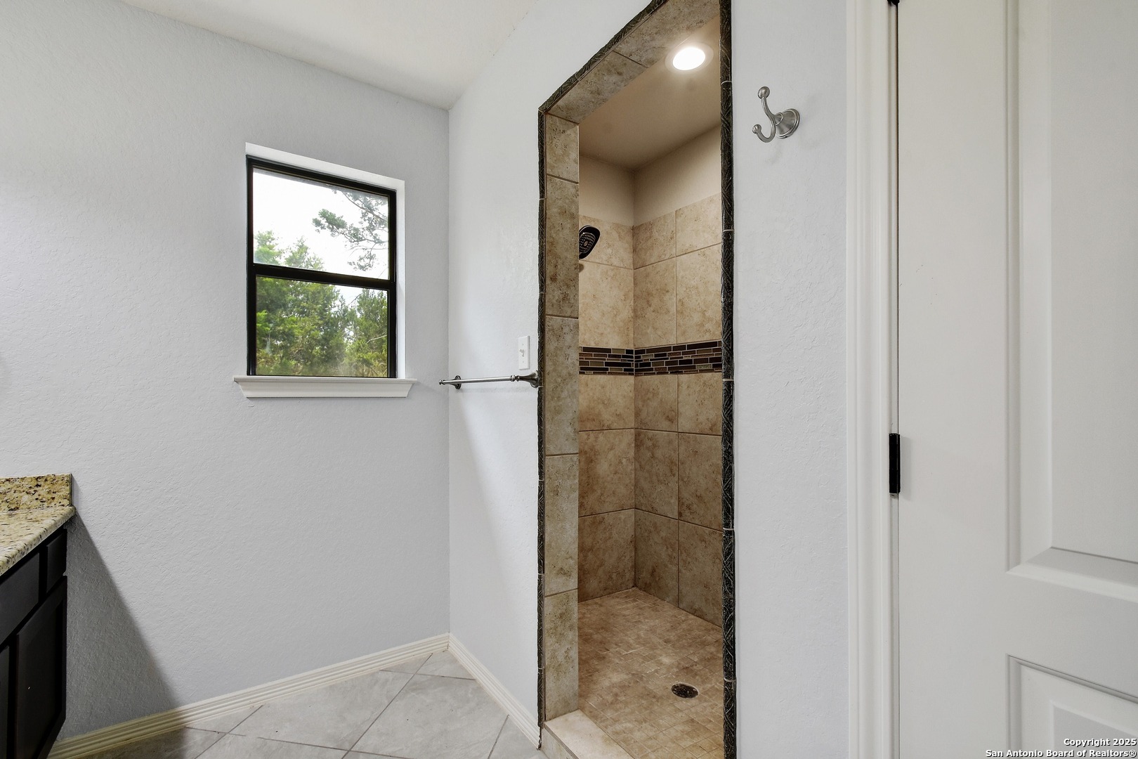 1010 Persimmon Pass Fischer, TX 78623 - Photo 17 of 26 a bathroom with a glass shower door and a window