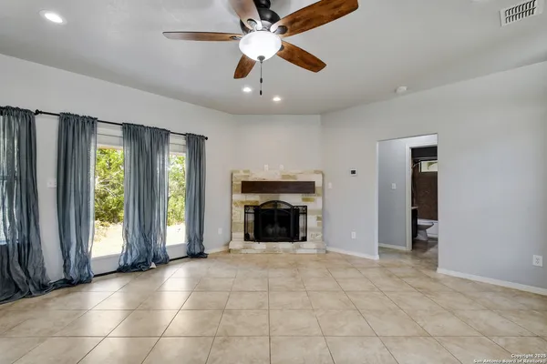 an empty room with fireplace and windows