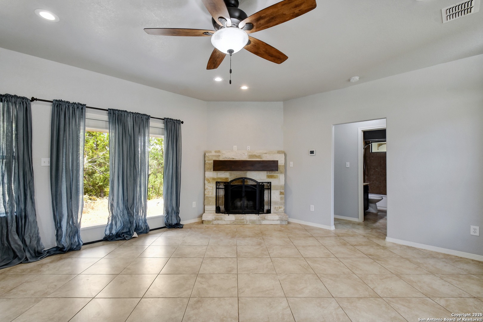 1010 Persimmon Pass Fischer, TX 78623 - Photo 4 of 26 an empty room with fireplace and windows