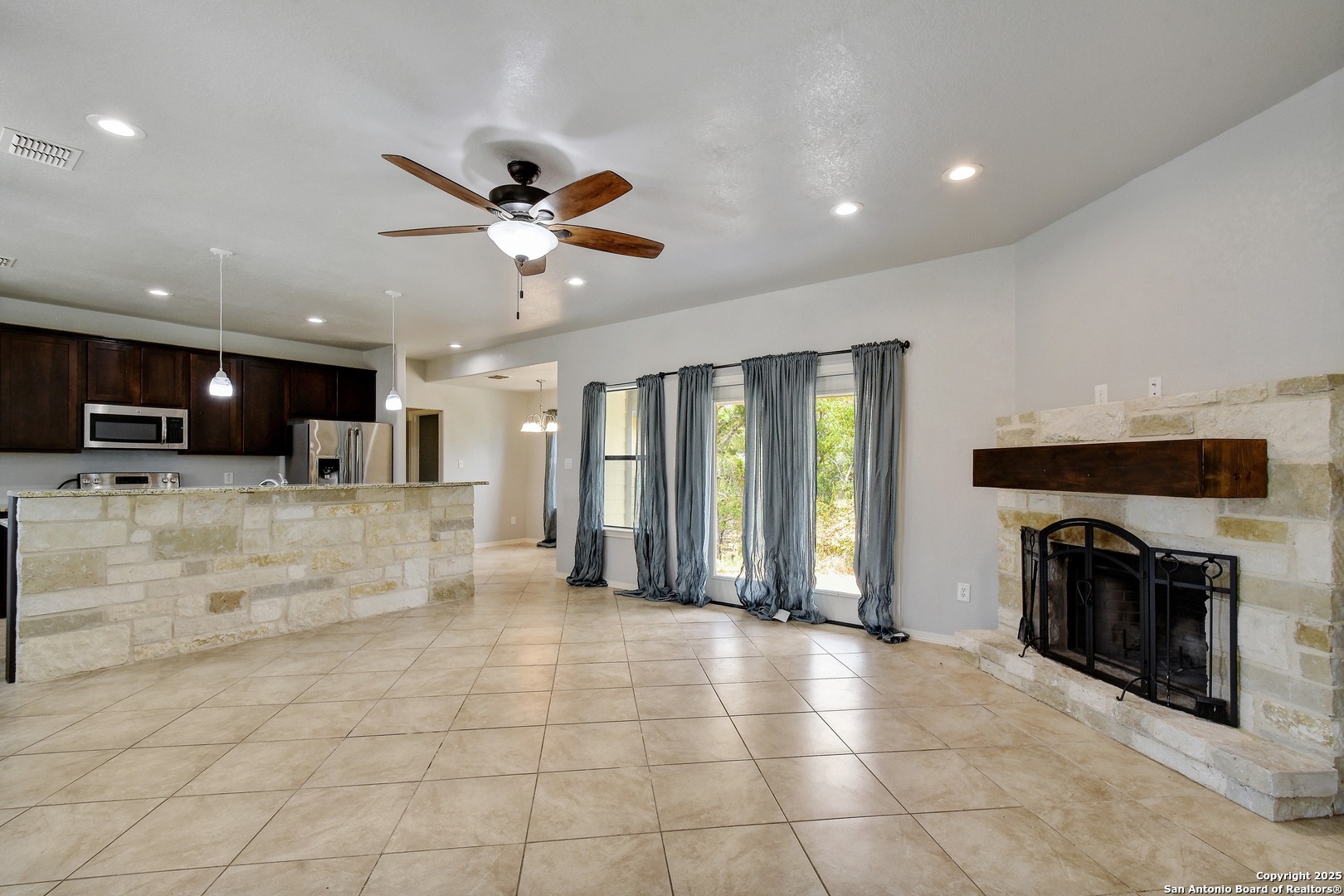 1010 Persimmon Pass Fischer, TX 78623 - Photo 5 of 26 a view of an empty room and kitchen with fireplace fan