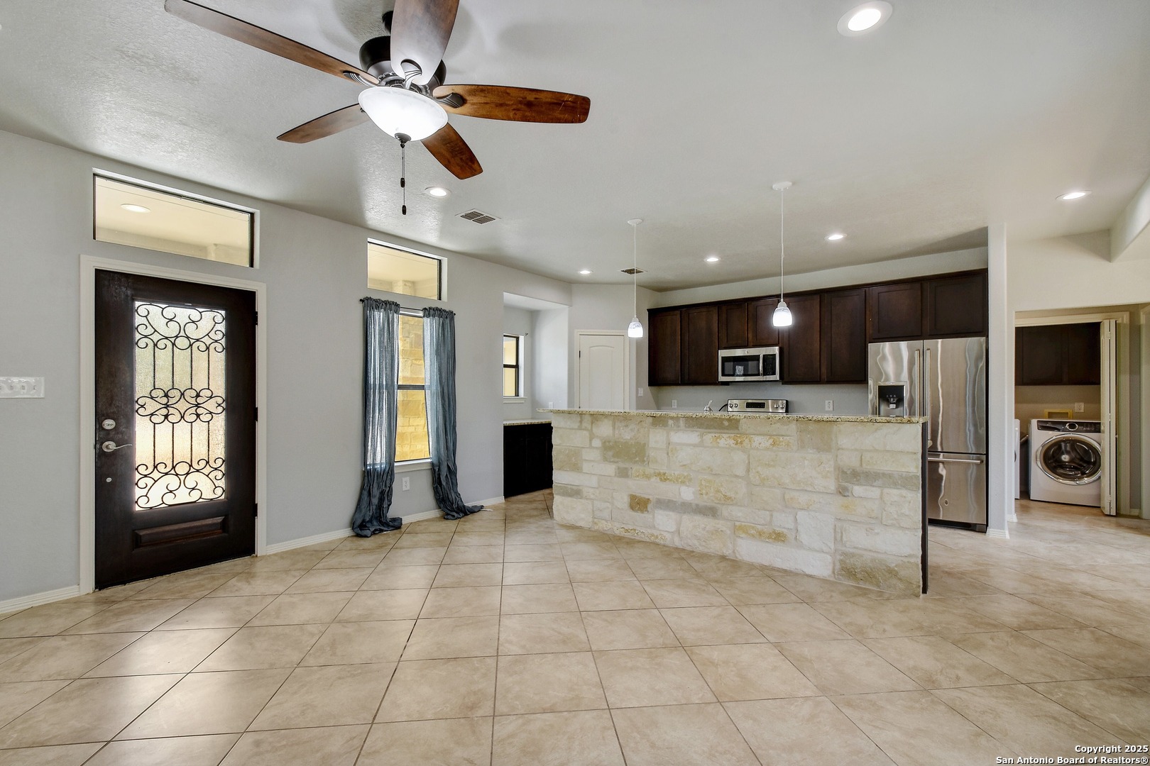 1010 Persimmon Pass Fischer, TX 78623 - Photo 7 of 26 a large kitchen with stainless steel appliances kitchen island granite countertop a refrigerator and a sink