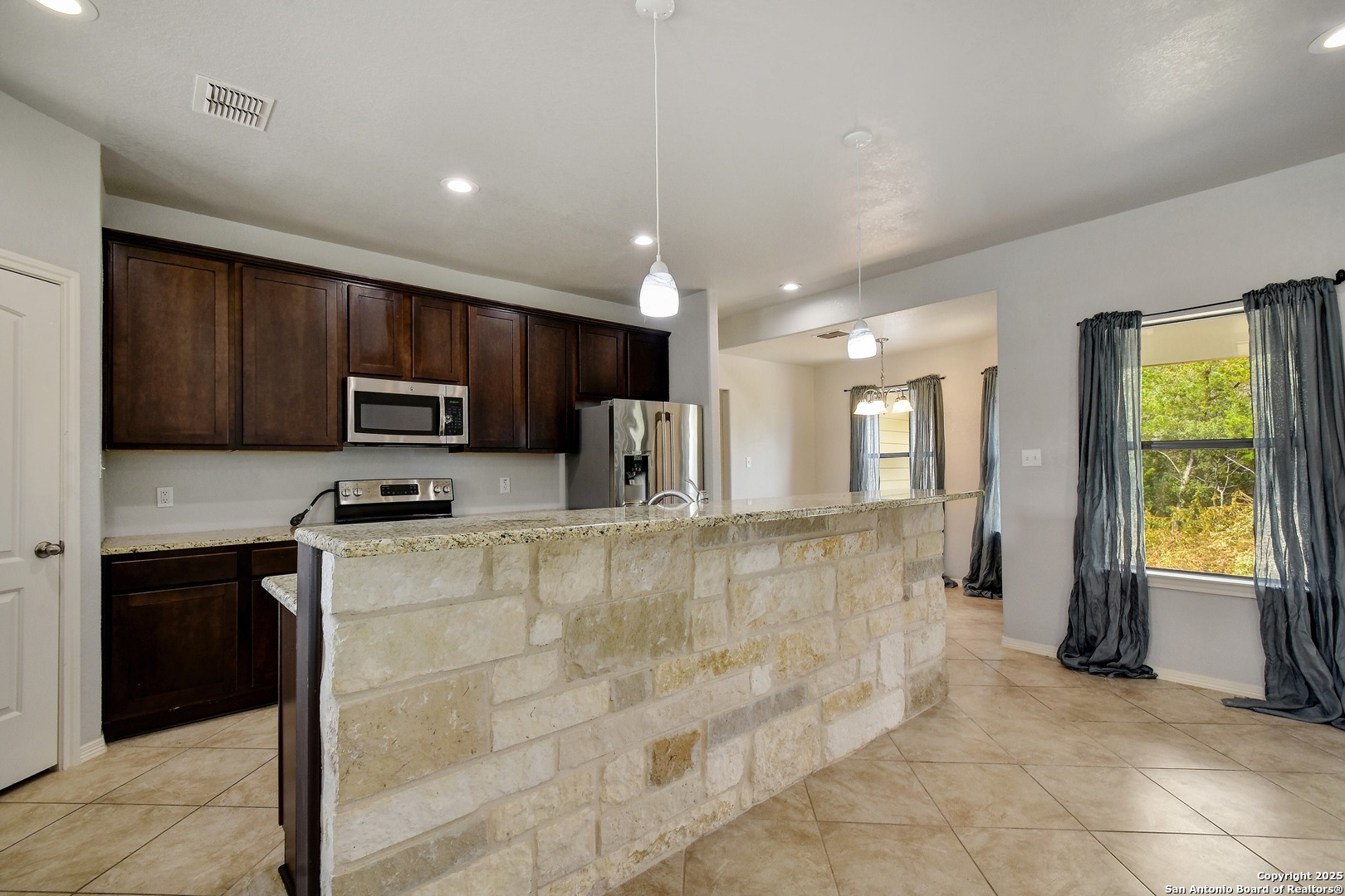 1010 Persimmon Pass Fischer, TX 78623 - Photo 8 of 26 a kitchen with stainless steel appliances granite countertop a refrigerator a stove a sink and a microwave