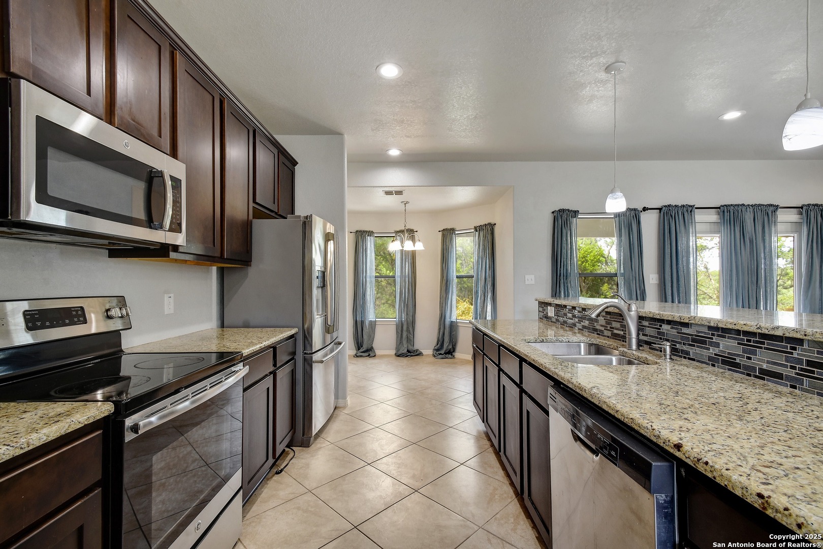 1010 Persimmon Pass Fischer, TX 78623 - Photo 9 of 26 a kitchen with stainless steel appliances granite countertop a sink stove and refrigerator