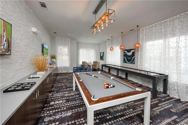a room with pool table and windows