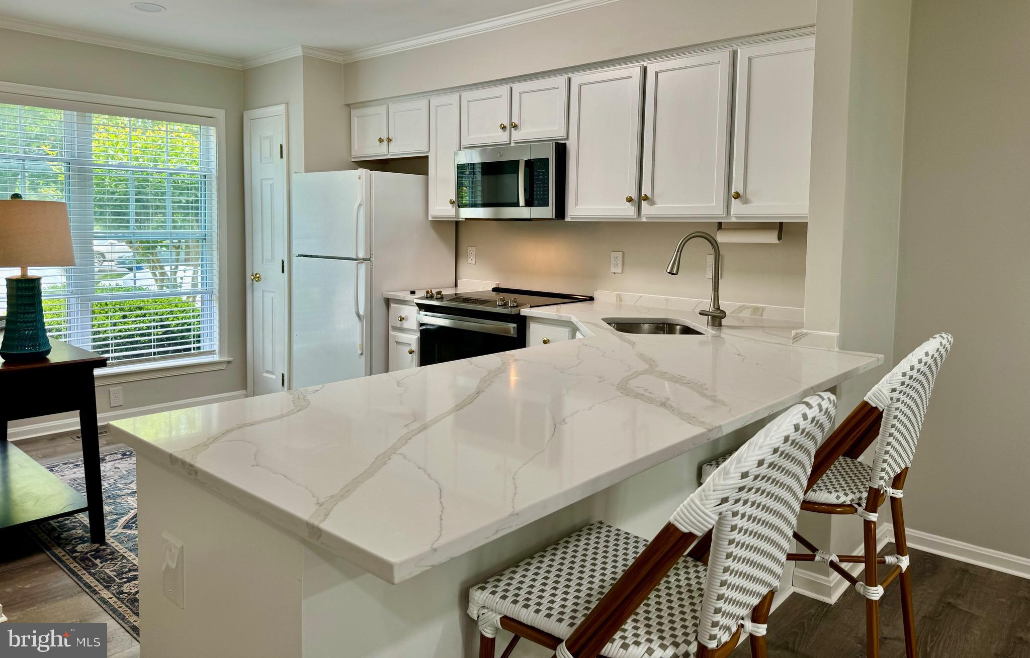 280 American Eagle Way, Unit 2806 Rehoboth Beach, DE 19971 - Photo 3 of 41 a kitchen with stainless steel appliances a stove a sink a microwave and cabinets
