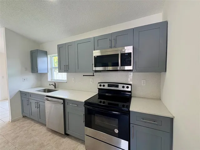 a kitchen with a sink and steel appliances