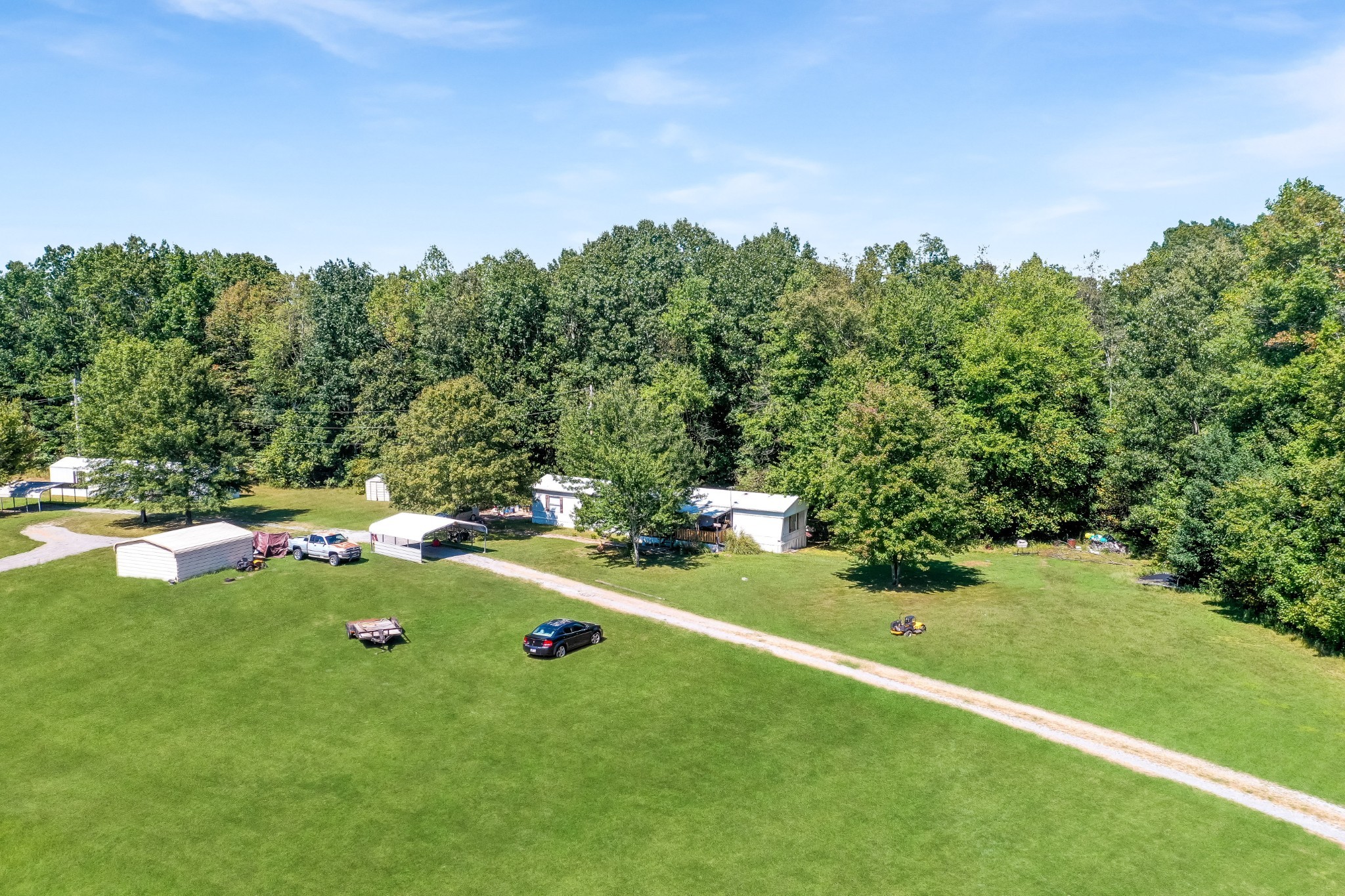 273 Running Meadows Road Portland, TN 37148 - Photo 4 of 20 a backyard of a house with table and chairs in a forest