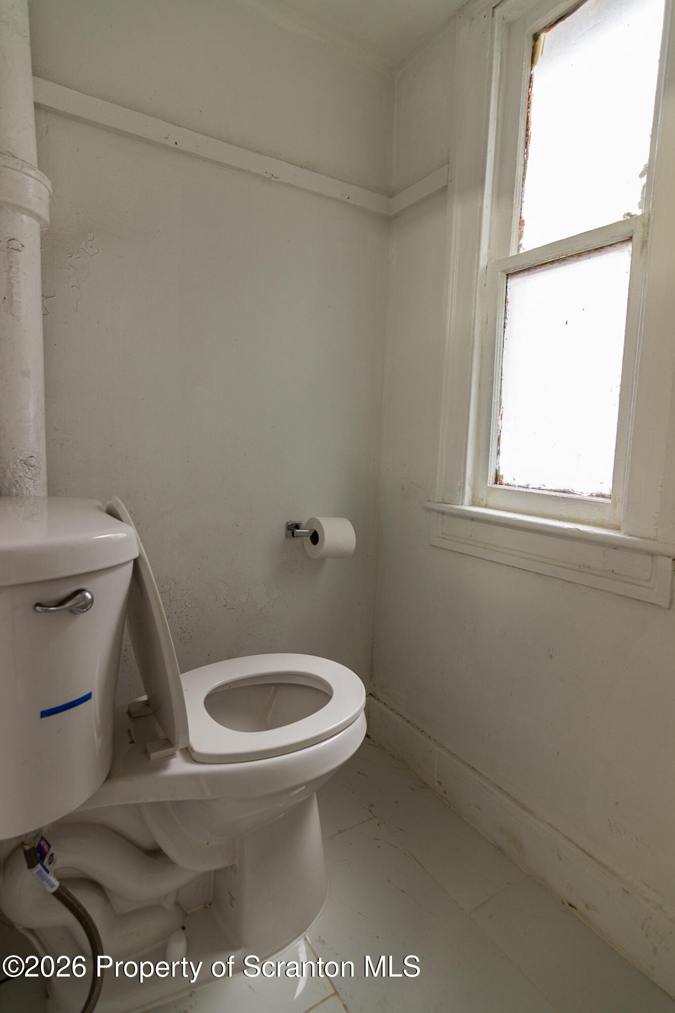 214 William Street Scranton, PA 18508 - Photo 28 of 33 a white toilet sitting next to a window and a shower