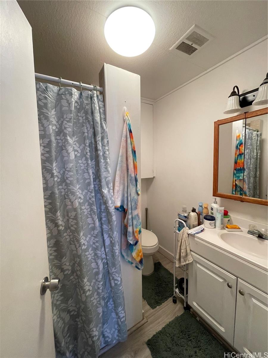 720 Mahiai Street Honolulu, HI 96826 - Photo 6 of 7 a bathroom with a sink toilet and a mirror