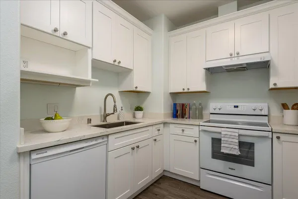 a kitchen with granite countertop white cabinets and white appliances
