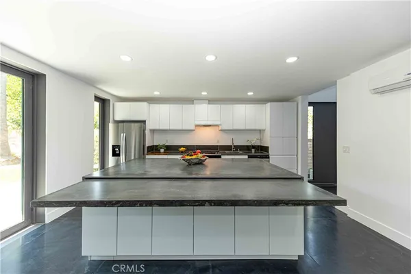 a view of kitchen with kitchen island a sink appliances and a window
