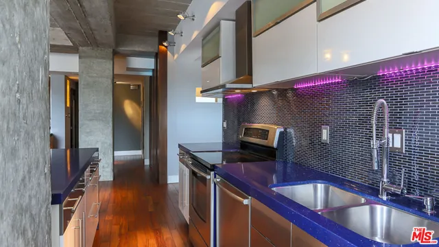 a kitchen with stainless steel appliances granite countertop a sink wooden cabinets and glass door