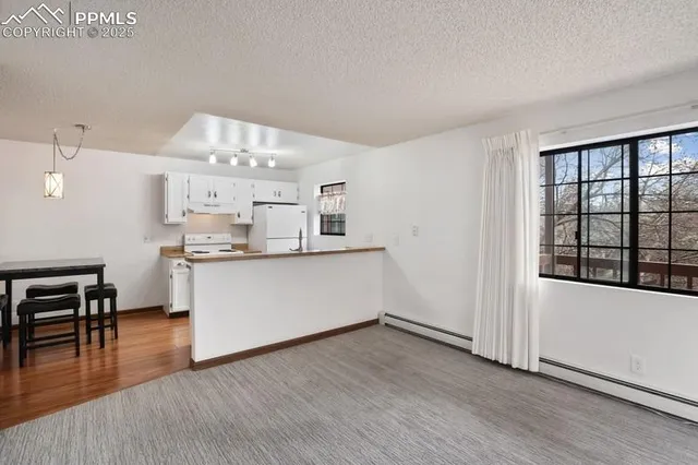 a view of a kitchen with wooden floor and a large window