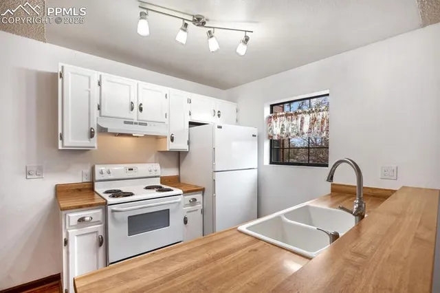 a kitchen with white cabinets and white appliances