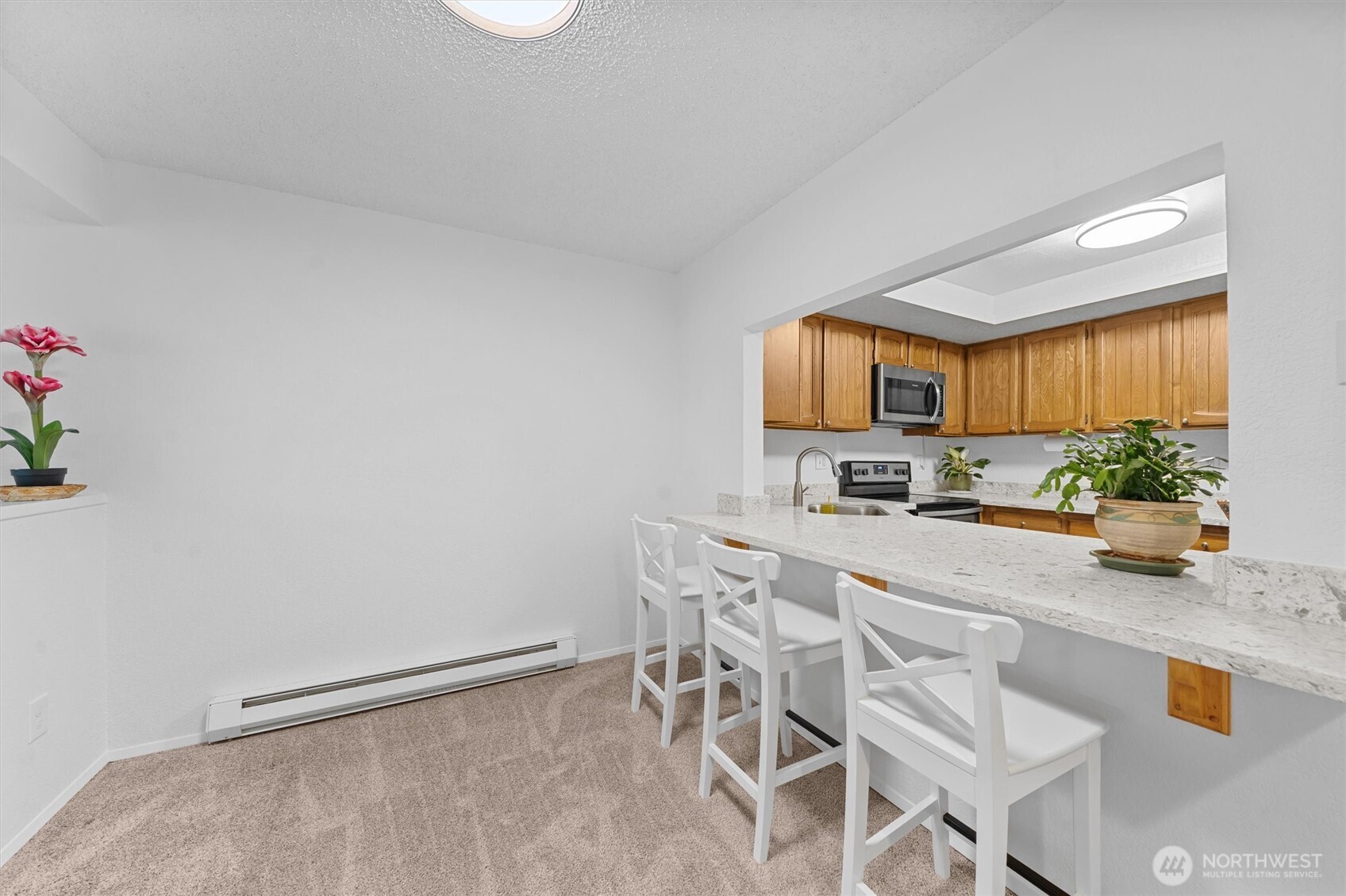 2515 Northeast 4th Street, Unit 522 Renton, WA 98056 - Photo 11 of 33 a kitchen with granite countertop lots of white cabinets and stainless steel appliances