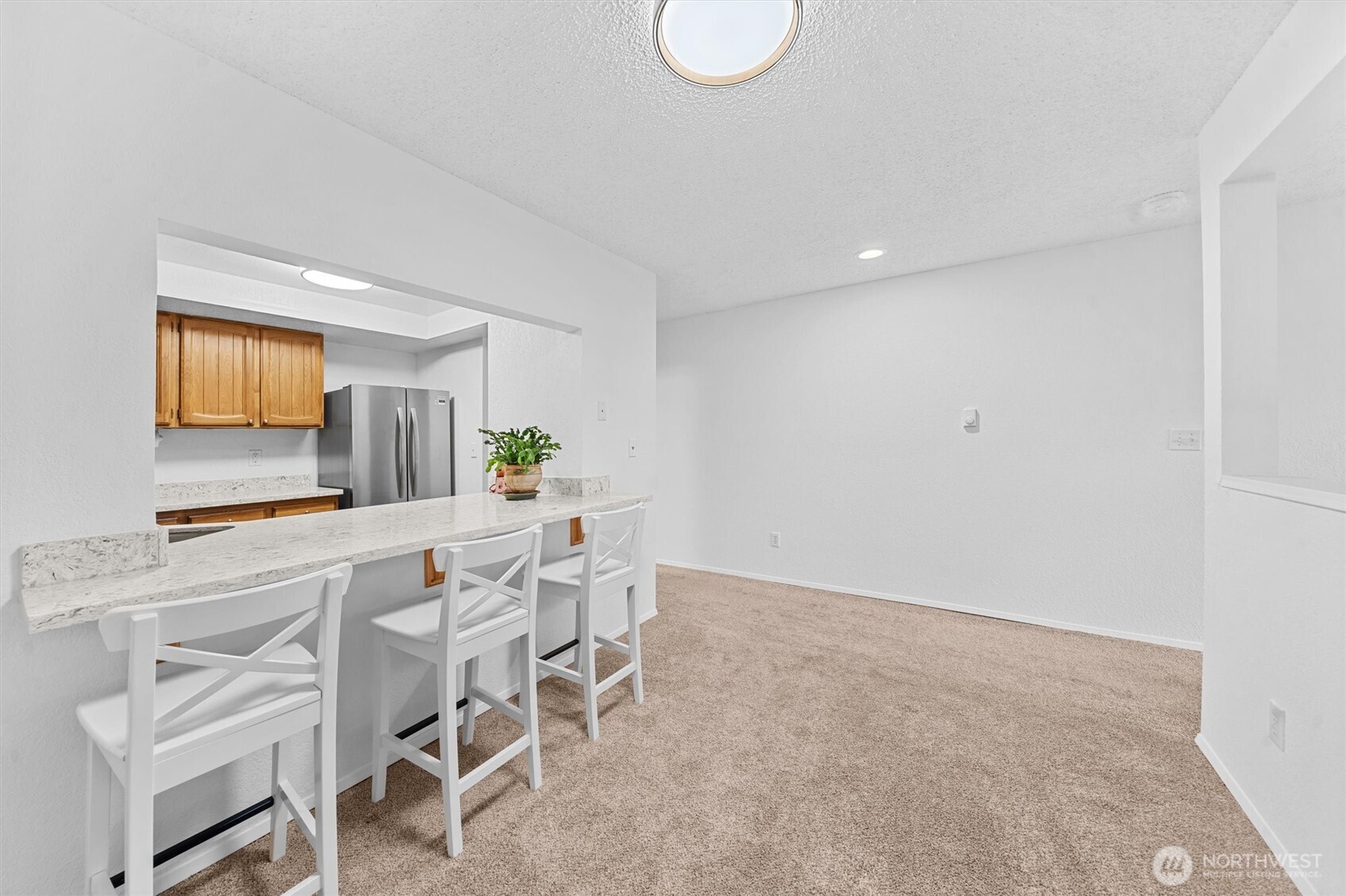 2515 Northeast 4th Street, Unit 522 Renton, WA 98056 - Photo 10 of 33 a kitchen with a dining table chairs and white cabinets
