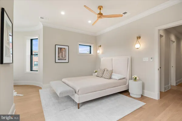 a spacious bedroom with a large bed and a chandelier