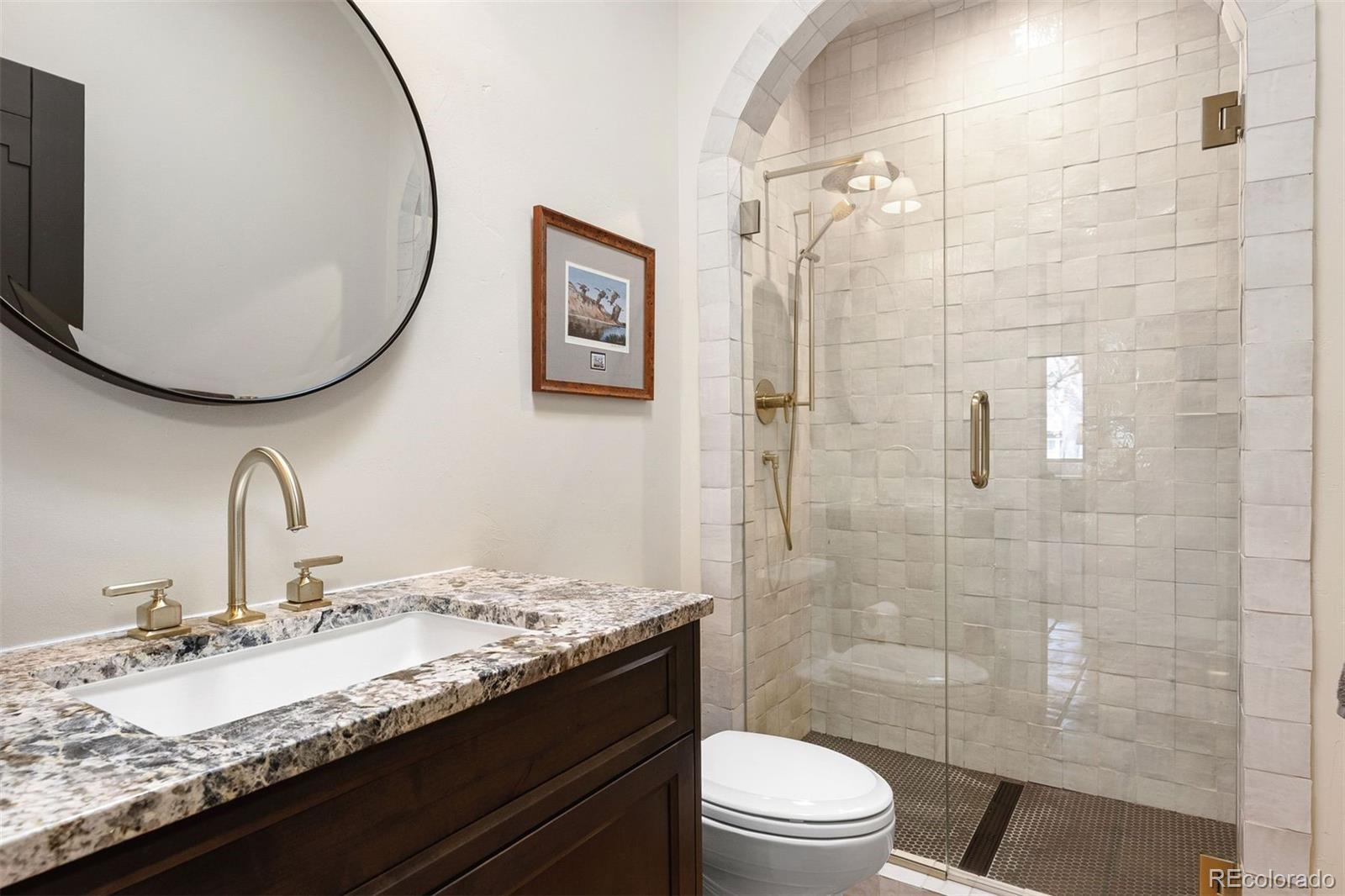 9 Polo Field Lane Denver, CO 80209 - Photo 17 of 36 a bathroom with a granite countertop sink toilet a mirror and shower