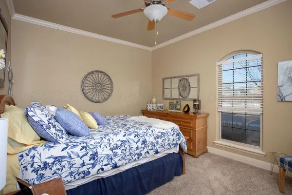 a bedroom with a bed a chandelier and a window