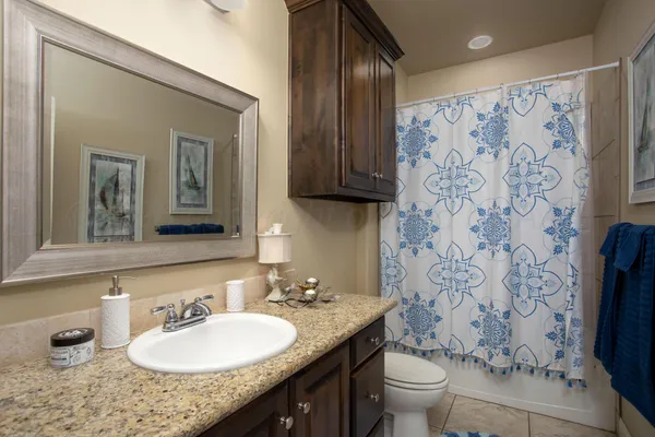 a bathroom with a granite countertop sink and a mirror