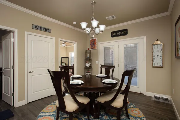 a view of a dining room with furniture a chandelier and wooden floor