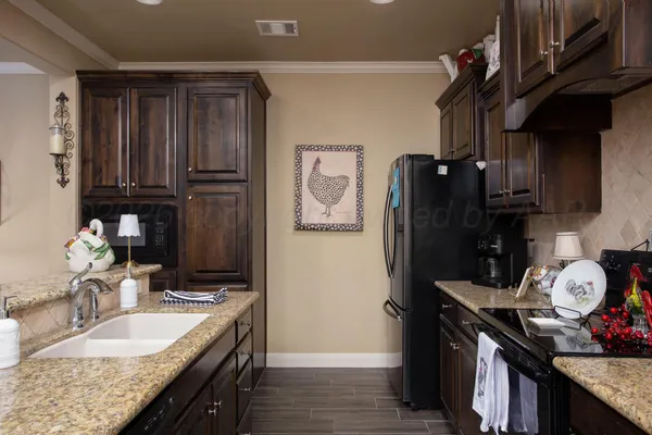 a kitchen with granite countertop a refrigerator a stove and a sink