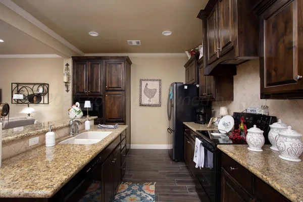 a kitchen with granite countertop a sink a stove and wooden cabinets