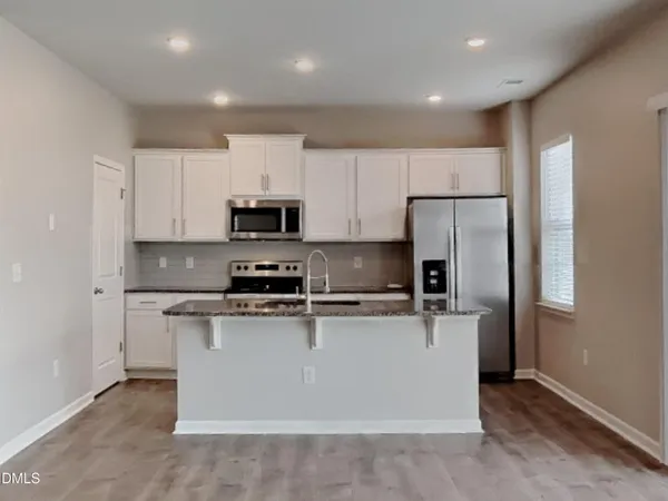 a kitchen with stainless steel appliances granite countertop a refrigerator stove a sink and a microwave