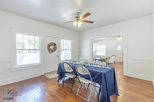 a view of a a dining room with furniture window and wooden floor