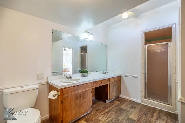 a bathroom with a granite countertop sink mirror vanity and toilet