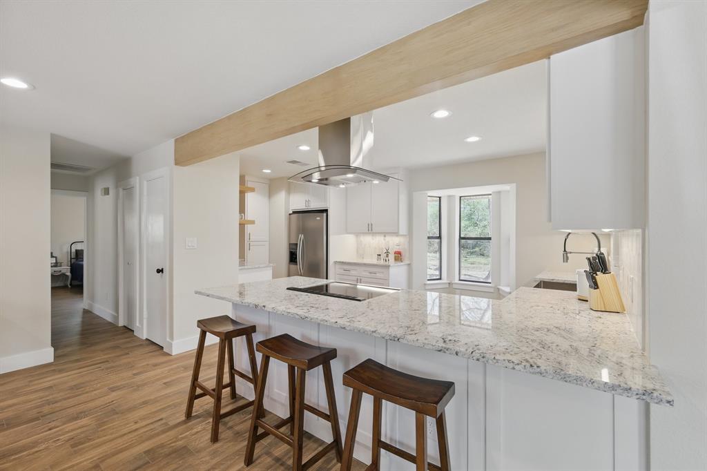 2446 Neely Trail Valley View, TX 76272 - Photo 6 of 29 a kitchen with granite countertop kitchen island cabinets and wooden floor
