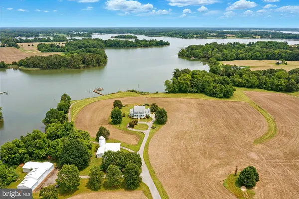 an aerial view of residential houses with outdoor space and lake view